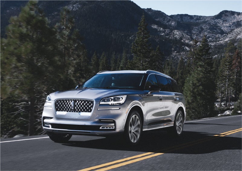 A 2023 Lincoln Aviator® Grand Touring SUV being driven on a winding road to demonstrate the capabilities of all-wheel drive | Bozard Lincoln in Saint Augustine FL