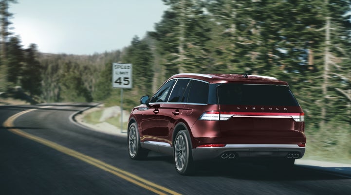 A 2024 Lincoln Aviator® SUV is being driven on a winding mountain road | Bozard Lincoln in Saint Augustine FL