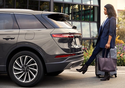 A woman with her hands full uses her foot to activate the available hands-free liftgate. | Bozard Lincoln in Saint Augustine FL