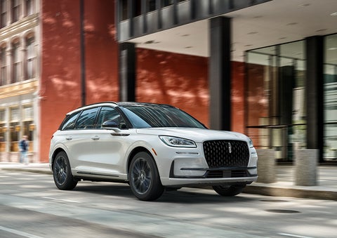 The 2024 Lincoln Corsair® SUV with the Jet Appearance Package and a Pristine White exterior is parked on a city street. | Bozard Lincoln in Saint Augustine FL