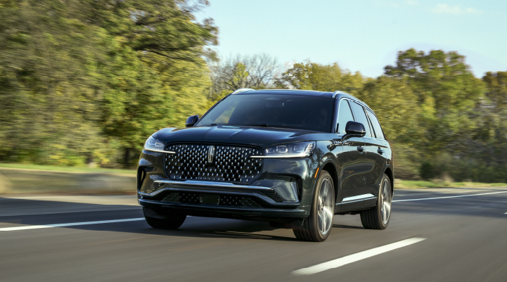 A 2025 Lincoln Black Label Aviator® SUV is being driven down a road lined with trees. | Bozard Lincoln in Saint Augustine FL