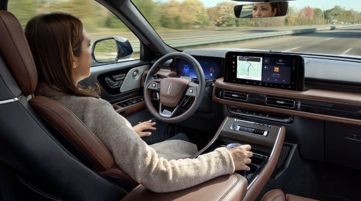 A 2026 Lincoln Aviator® SUV is being driven hands-free on a highway near a forest | Bozard Lincoln in Saint Augustine FL