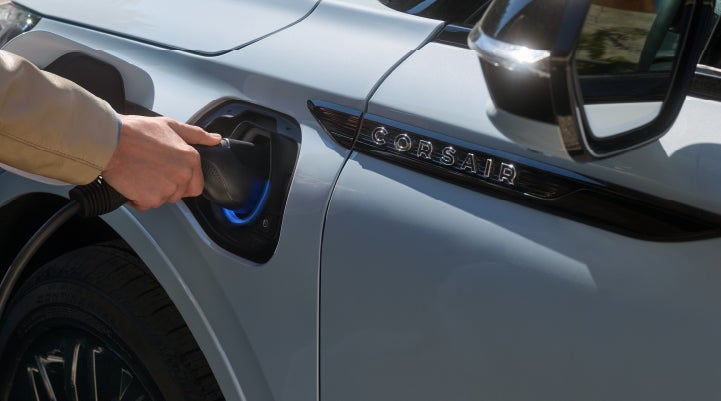 A hand is plugging in a 2026 Lincoln Corsair® Grand Touring Plug-in Hybrid SUV. | Bozard Lincoln in Saint Augustine FL