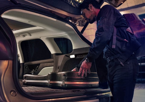 A man is shown loading cargo into the rear of a 2026 Lincoln Corsair® SUV with the second-row seats folded flat. | Bozard Lincoln in Saint Augustine FL