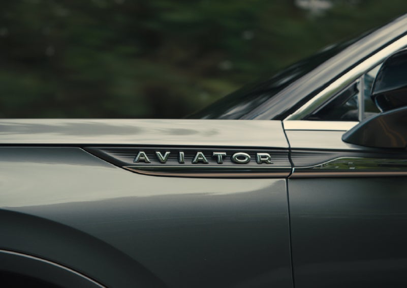 The driver’s side door and fender badging of a gray 2027 Lincoln Aviator® SUV are showcased. | Bozard Lincoln in Saint Augustine FL