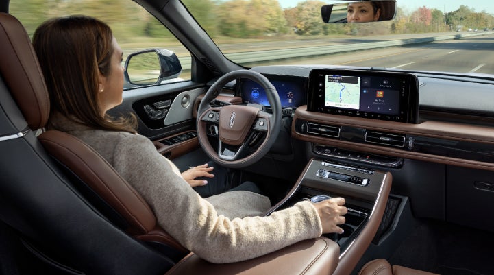 A 2027 Lincoln Aviator® SUV is being driven hands-free on a highway lined with trees. | Bozard Lincoln in Saint Augustine FL
