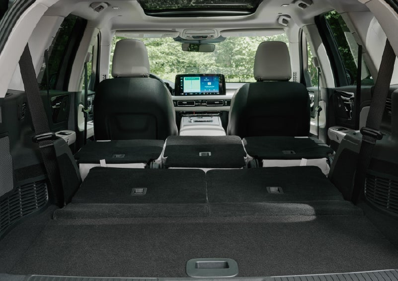 A rear to front view of the interior of a 2027 Lincoln Aviator® Black Label™ SUV shows the third and second rows folded flat | Bozard Lincoln in Saint Augustine FL